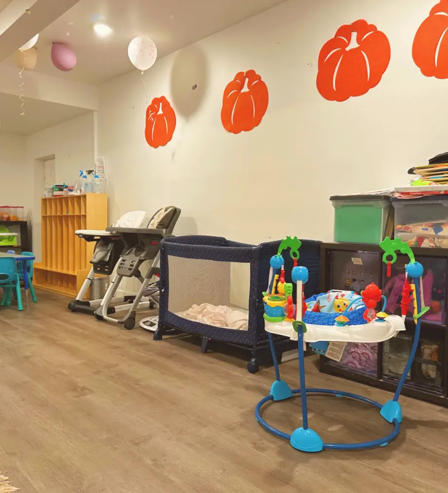 Infant and toddler care area with play equipment and organized supplies