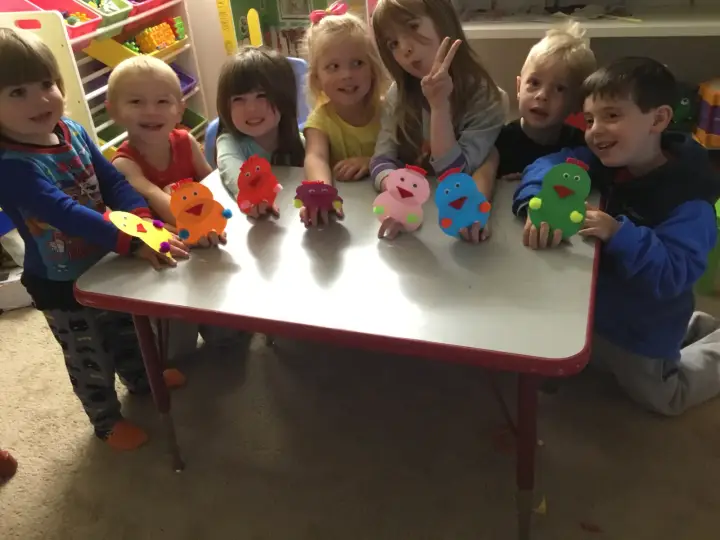 Children showing colorful craft projects during daycare activity time in Lynnwood